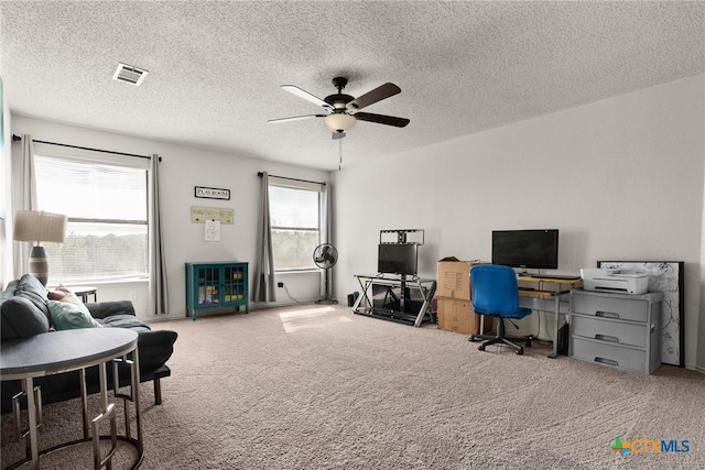 carpeted office featuring a textured ceiling and ceiling fan