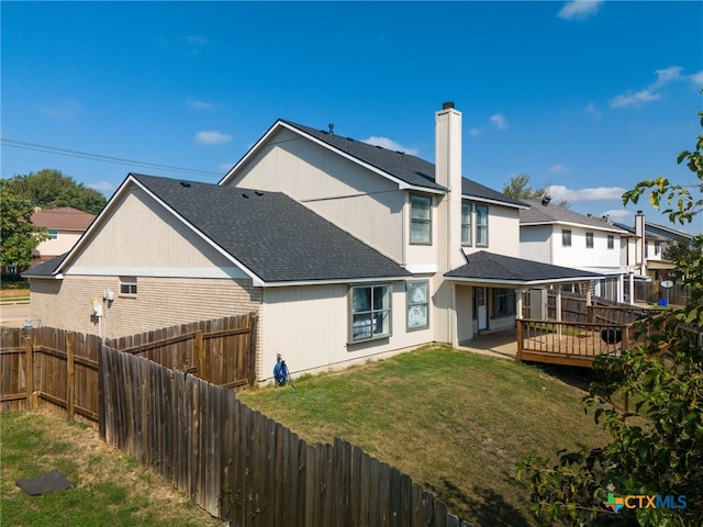 rear view of house with a lawn and a deck