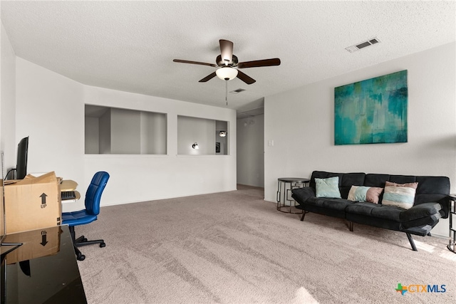 home office with a textured ceiling, carpet floors, and ceiling fan