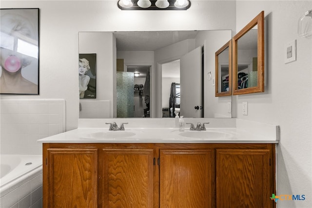 bathroom with a relaxing tiled tub, vanity, and a healthy amount of sunlight