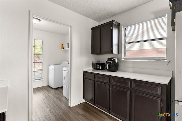 interior space featuring separate washer and dryer, dark hardwood / wood-style flooring, a healthy amount of sunlight, and a textured ceiling