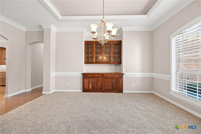 2206 Pheasant Run Ln, Temple, TX 76502 - spare room with a tray ceiling, arched walkways, a chandelier, crown molding, and carpet flooring