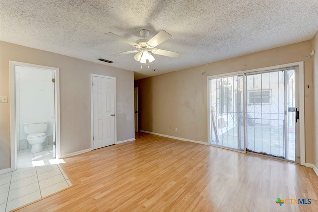 unfurnished room featuring light hardwood / wood-style floors, a textured ceiling, and ceiling fan