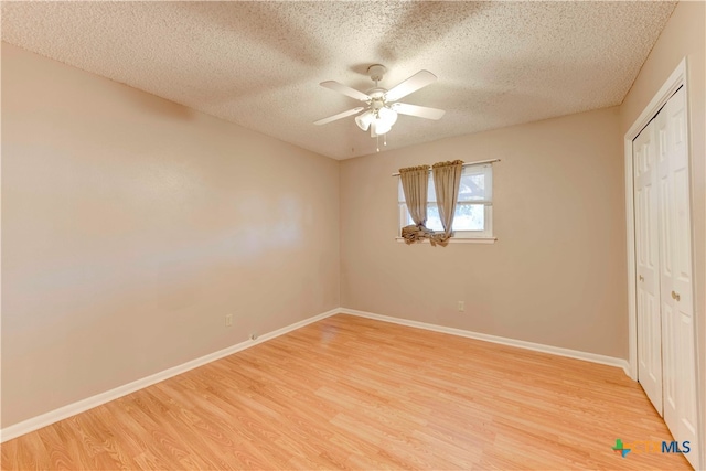 unfurnished bedroom featuring a textured ceiling, light hardwood / wood-style flooring, ceiling fan, and a closet