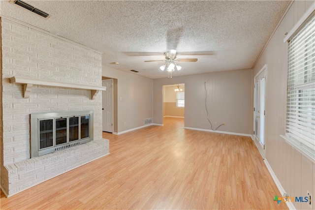 unfurnished living room featuring a wealth of natural light, a textured ceiling, and light hardwood / wood-style flooring