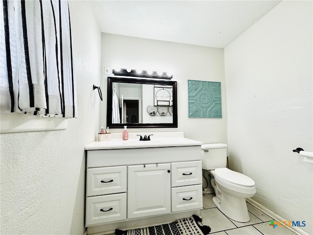 bathroom featuring tile patterned flooring, vanity, and toilet