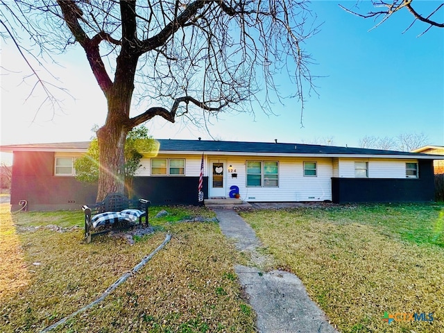 single story home featuring a front lawn