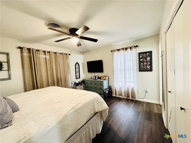 bedroom featuring a textured ceiling, dark hardwood / wood-style floors, and ceiling fan