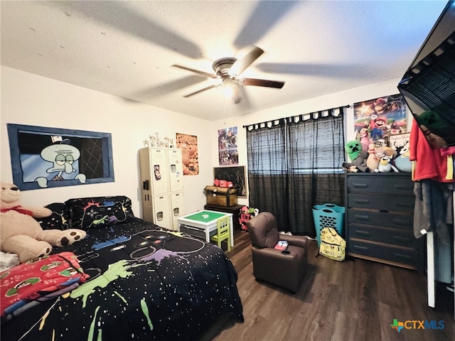 bedroom with ceiling fan, wood-type flooring, and a textured ceiling