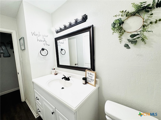 bathroom featuring hardwood / wood-style floors, vanity, and toilet