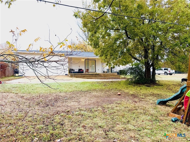 view of yard featuring a playground and a garage