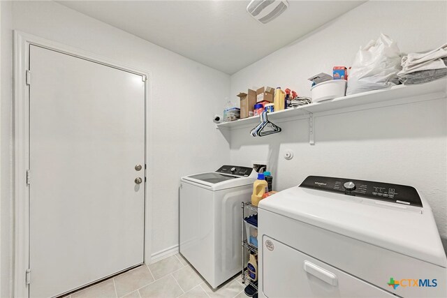 laundry area featuring washer and clothes dryer and light tile patterned floors