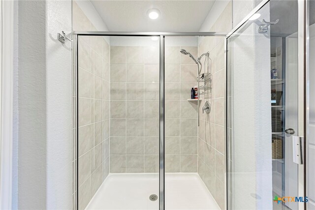 bathroom featuring a shower with door