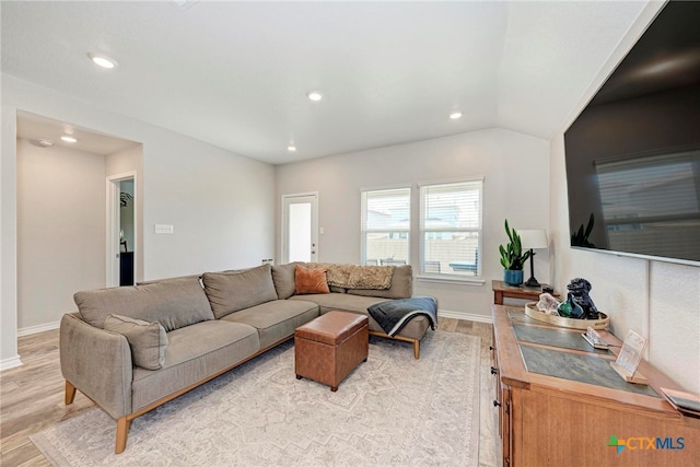 living room featuring light hardwood / wood-style flooring and vaulted ceiling