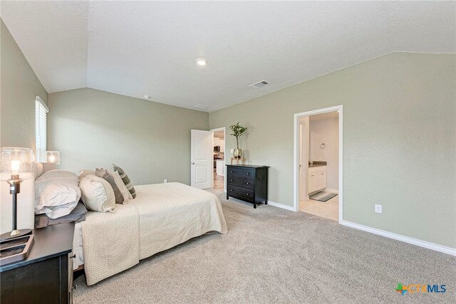 carpeted bedroom with connected bathroom and lofted ceiling