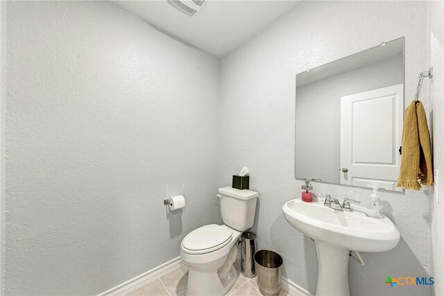 bathroom featuring toilet and tile patterned flooring