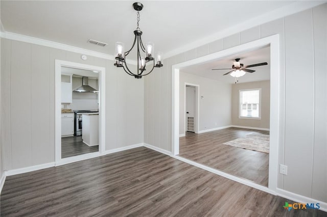 unfurnished dining area featuring crown molding, visible vents, dark wood-type flooring, baseboards, and ceiling fan with notable chandelier