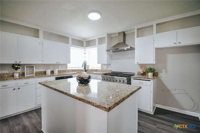 kitchen featuring a center island, white cabinets, range, light stone countertops, and wall chimney exhaust hood