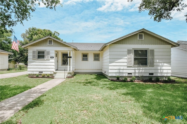 single story home featuring crawl space, roof with shingles, and a front yard