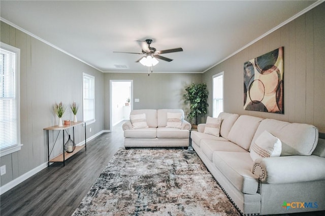 living area with ornamental molding, dark wood-style flooring, and plenty of natural light