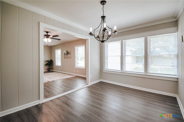 unfurnished dining area featuring dark wood-type flooring, baseboards, and ceiling fan with notable chandelier