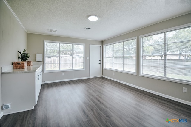 interior space with ornamental molding, dark wood-style flooring, visible vents, and a textured ceiling