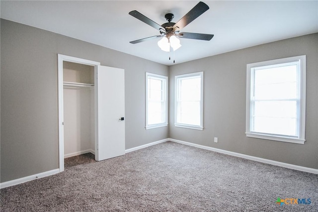 unfurnished bedroom featuring ceiling fan, a closet, carpet, and baseboards