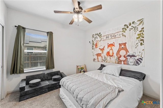 carpeted bedroom with a ceiling fan and baseboards