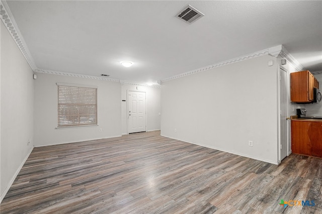 unfurnished living room with crown molding and dark hardwood / wood-style flooring