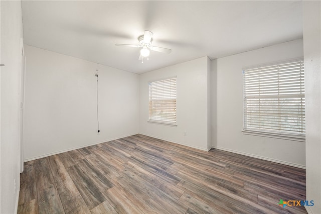 spare room with ceiling fan and dark hardwood / wood-style floors