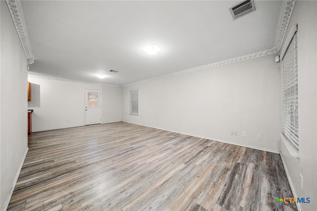 spare room featuring hardwood / wood-style floors and crown molding