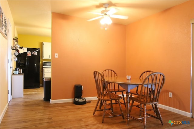 dining area with light wood-type flooring and ceiling fan