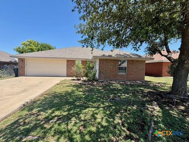 4306 Menard Dr, Killeen, TX 76549 - ranch-style home with brick siding, a garage, driveway, and a front lawn
