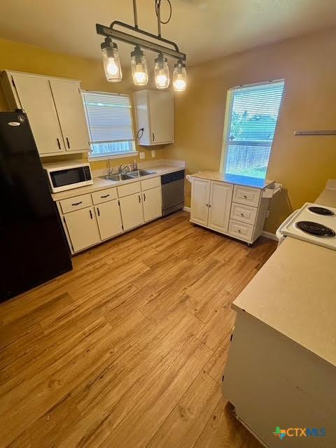 4306 Menard Dr, Killeen, TX 76549 - kitchen featuring a sink, white appliances, white cabinets, and light countertops