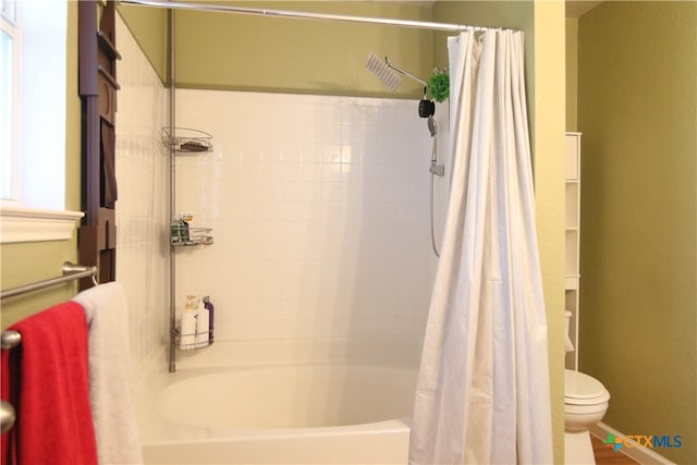 bathroom with toilet and shower / bath combo with shower curtain