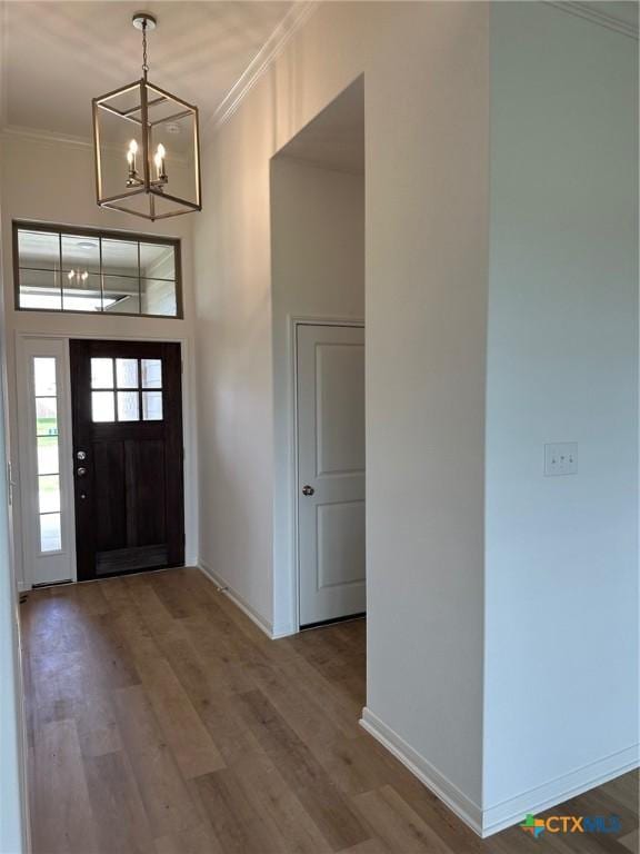 7213 Touchstone Dr, Temple, TX 76502 - foyer featuring ornamental molding, a chandelier, baseboards, wood finished floors, and a towering ceiling