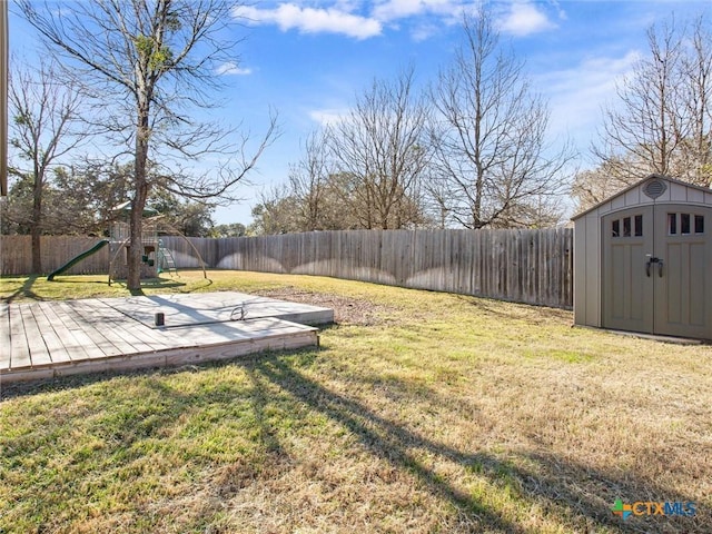 view of yard featuring a playground and a storage unit