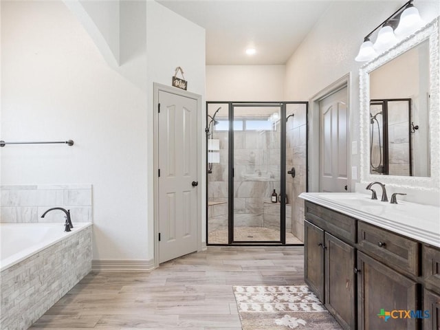 bathroom with hardwood / wood-style flooring, vanity, and shower with separate bathtub