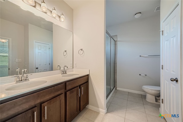 bathroom with walk in shower, vanity, toilet, and tile patterned floors