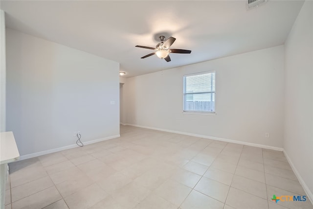 tiled spare room with ceiling fan