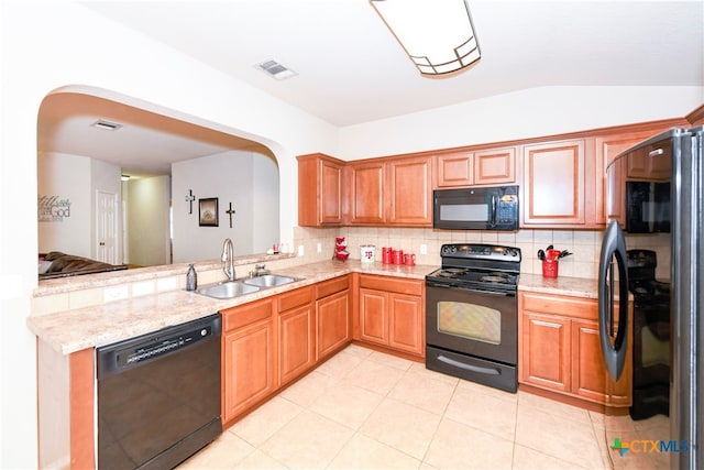 kitchen featuring light tile patterned flooring, sink, black appliances, vaulted ceiling, and decorative backsplash