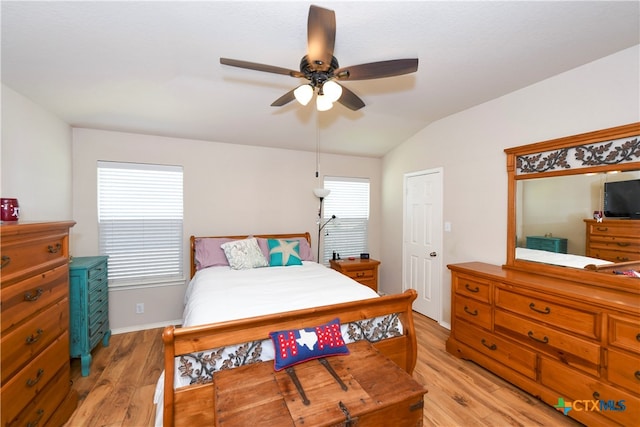 bedroom with ceiling fan, light hardwood / wood-style flooring, and vaulted ceiling