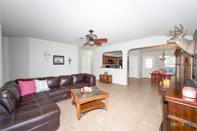 living room with ceiling fan with notable chandelier and light tile patterned floors