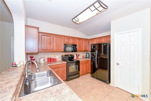 kitchen with lofted ceiling, black appliances, sink, light tile patterned flooring, and backsplash