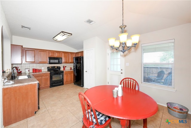 tiled dining room featuring sink, an inviting chandelier, and vaulted ceiling