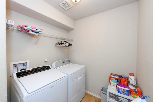 clothes washing area featuring light tile patterned flooring and separate washer and dryer