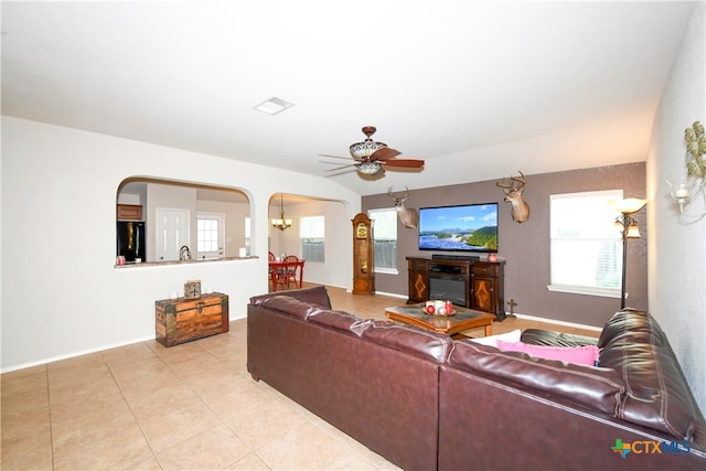 living room with light tile patterned floors, ceiling fan, and a fireplace