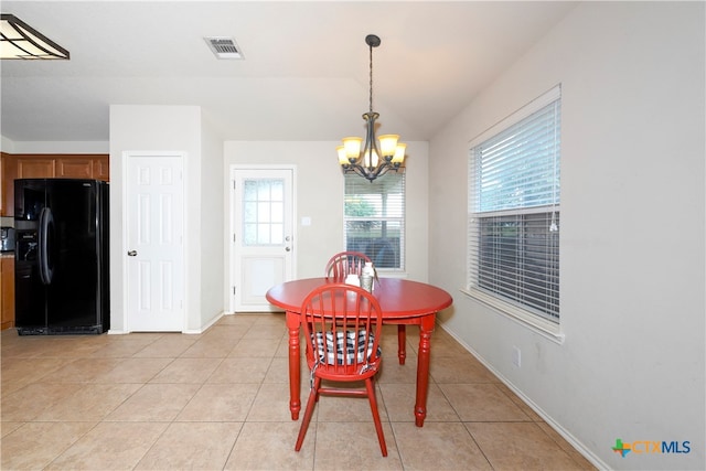 tiled dining space with a chandelier