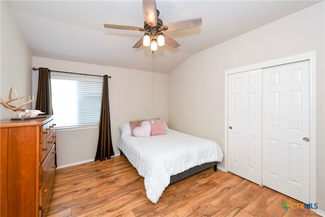 bedroom with a closet, light wood-type flooring, lofted ceiling, and ceiling fan