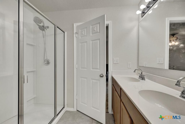 bathroom with a shower stall, tile patterned floors, and double vanity